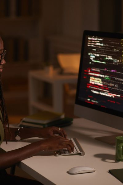 side-view-portrait-contemporary-african-american-woman-writing-code-looking-computer-screen-while-working-dark-office-copy-space